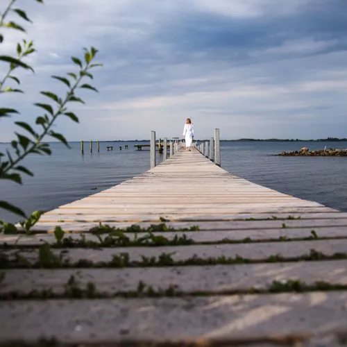 Kvinde I Mogenkåbe På Badebro